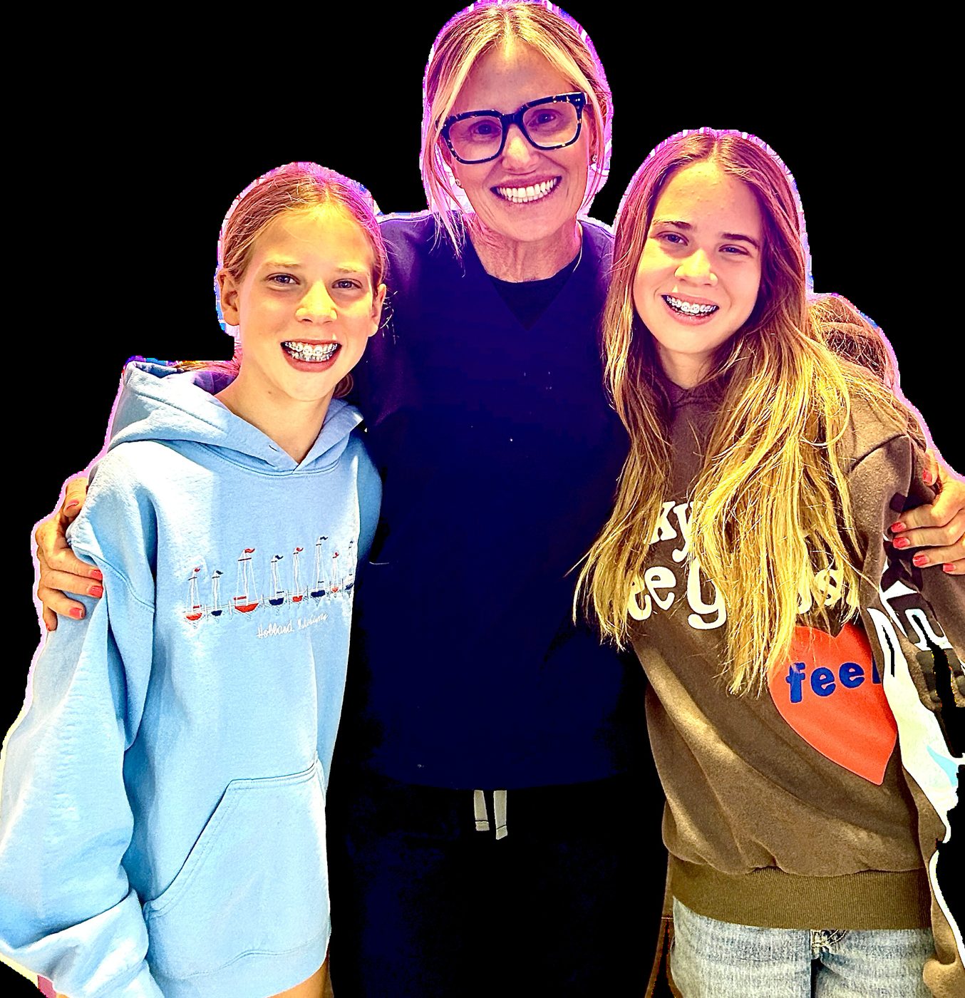 Two smiling teen patients with a Miller Orthodontics team member