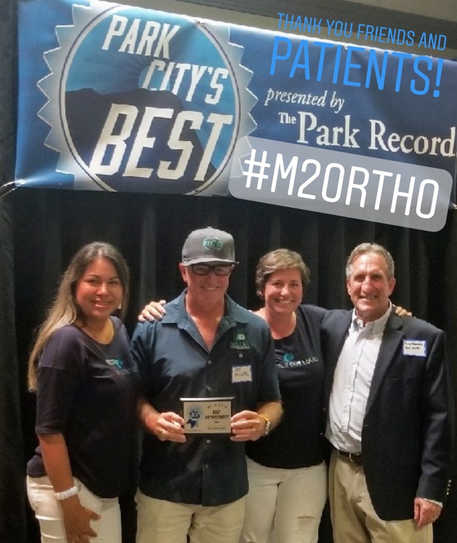 Miller Orthodontics accepting the 2018 Best Orthodontist plaque in front of the Park City's Best banner presented by The Park Record
